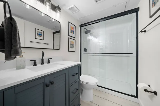 a bathroom with a granite countertop sink mirror vanity and toilet