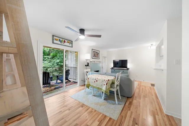 a living room with furniture a flat screen tv and a floor to ceiling window