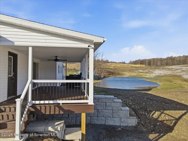 a view of empty room with wooden floor and ceiling fan