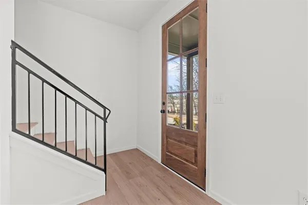 a view of a hallway with wooden floor and windows