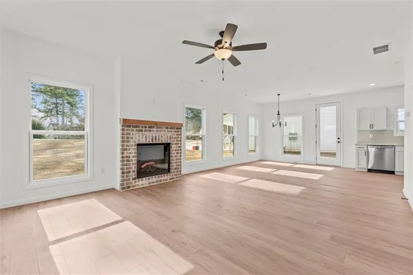 a view of an empty room with a fireplace and a window