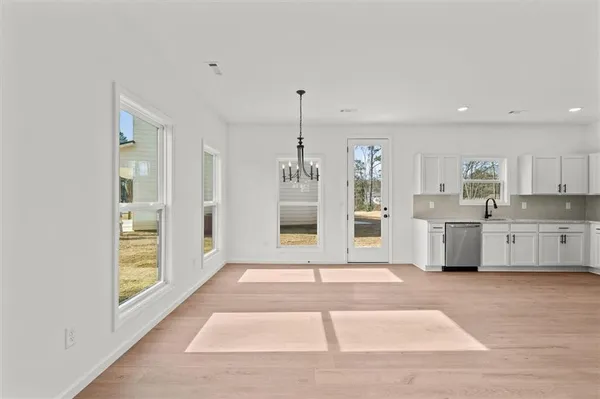 a view of a kitchen with a sink and dishwasher a refrigerator with wooden floor