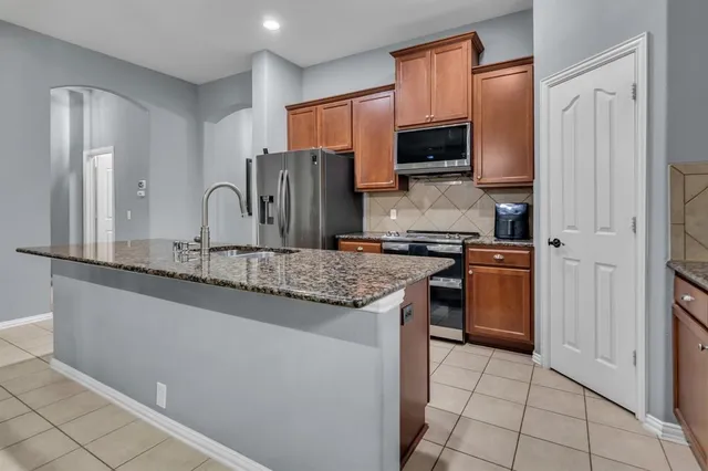 a kitchen with stainless steel appliances granite countertop a refrigerator and a sink