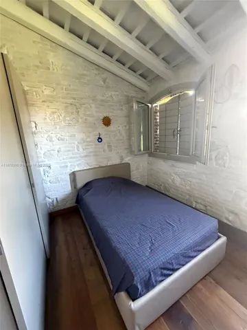 a spacious bedroom with a bed a window and flat screen tv