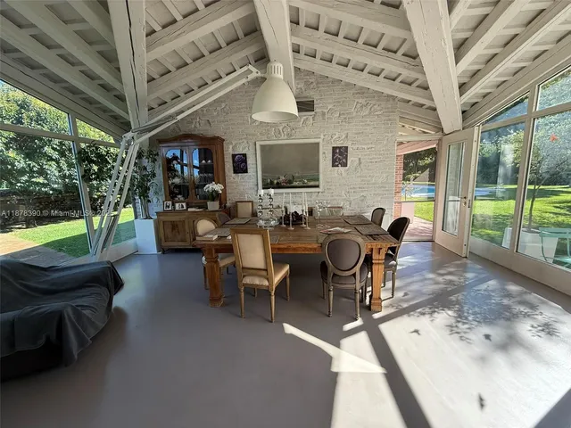 a living room with furniture a flat screen tv and a floor to ceiling window