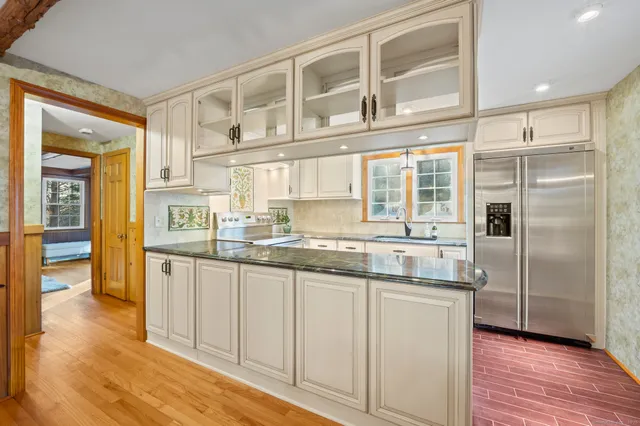 a kitchen with stainless steel appliances granite countertop a refrigerator and wooden cabinets