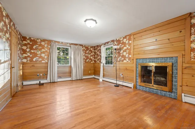 a view of an empty room with a fireplace and a window