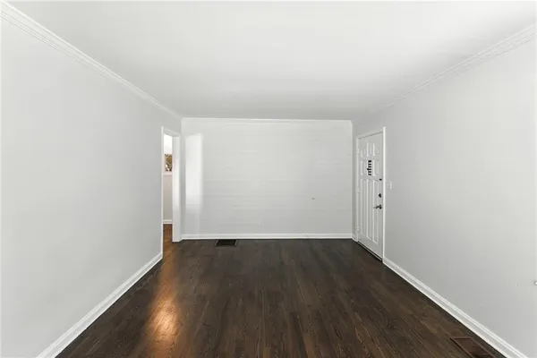 a view of an empty room with wooden floor