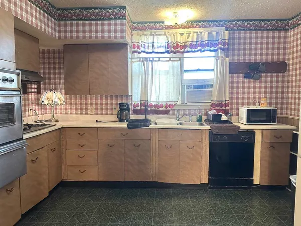 a kitchen with a sink cabinets and window