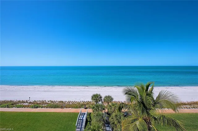 a living room with patio furniture and a large window