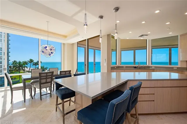 a living room with furniture kitchen view and a large window