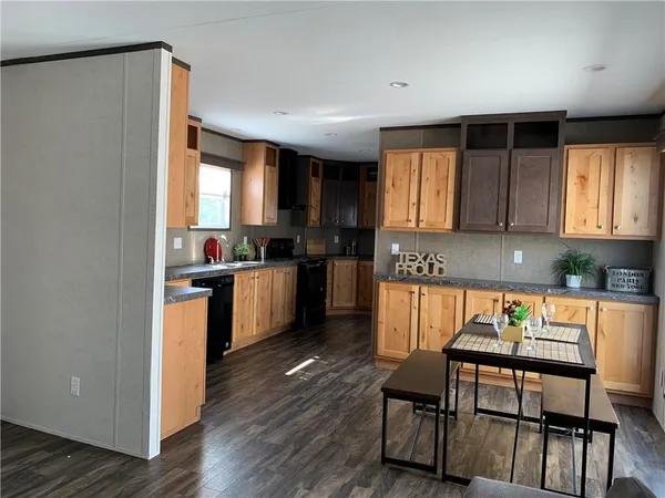 a kitchen with granite countertop a stove a sink and a refrigerator