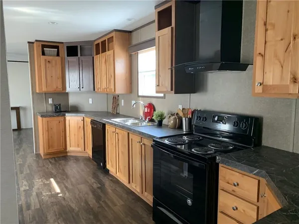 a kitchen with granite countertop a sink a stove and cabinets