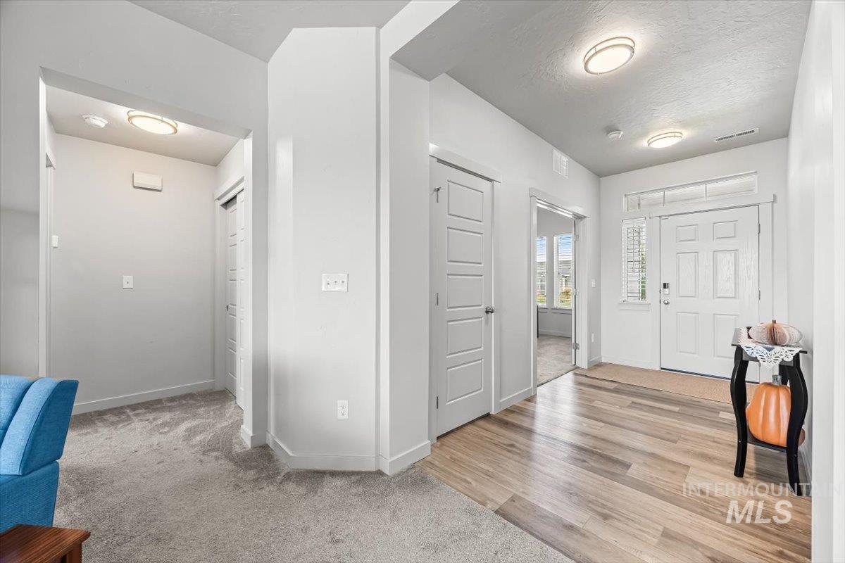 15365 Lutsen Avenue Caldwell, ID 83607 - Photo 11 of 42 Entryway featuring a textured ceiling, light colored carpet, and light wood-style flooring