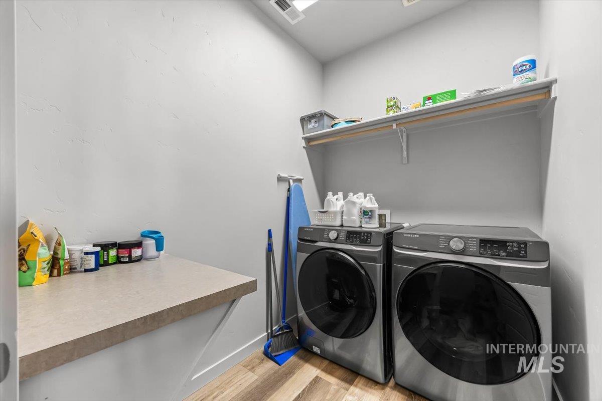15365 Lutsen Avenue Caldwell, ID 83607 - Photo 16 of 42 Laundry area featuring light wood finished floors and washing machine and clothes dryer