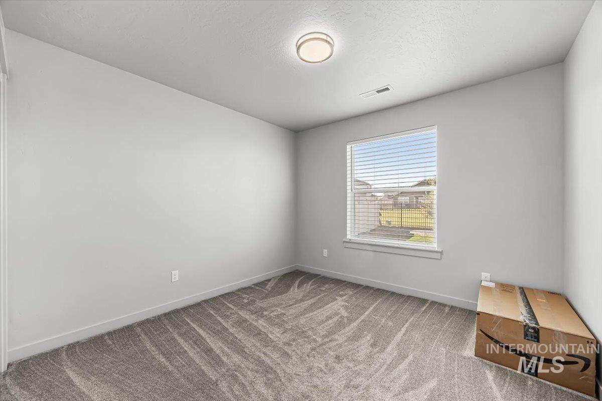 15365 Lutsen Avenue Caldwell, ID 83607 - Photo 22 of 42 Spare room featuring light carpet and a textured ceiling