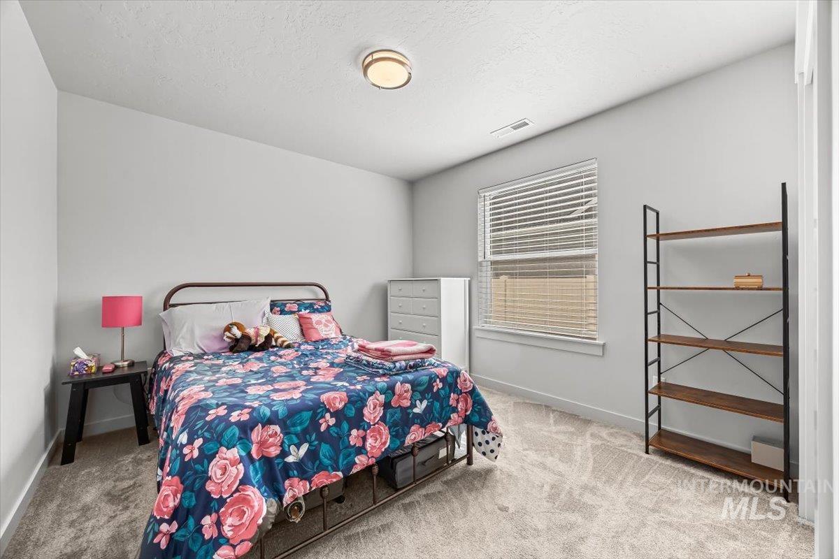 15365 Lutsen Avenue Caldwell, ID 83607 - Photo 26 of 42 Bedroom with light colored carpet and a textured ceiling