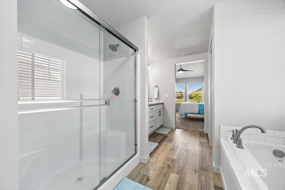 15365 Lutsen Avenue Caldwell, ID 83607 - Photo 30 of 42 Ensuite bathroom with vanity, a stall shower, a bath, and light wood finished floors