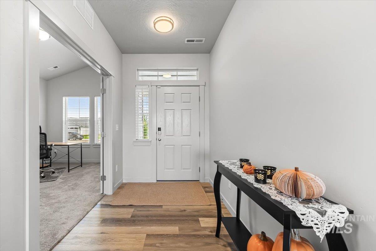 15365 Lutsen Avenue Caldwell, ID 83607 - Photo 5 of 42 Entryway featuring light wood-type flooring, lofted ceiling, a textured ceiling, and light carpet