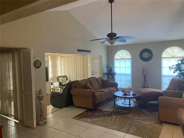 a living room with couches a fireplace and a window