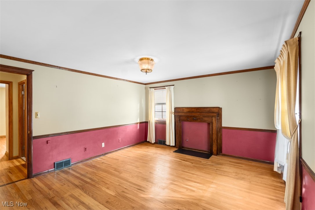 3609 Brinkmore Road Cleveland, OH 44121 - Photo 21 of 50 Spare room with crown molding , fireplace mantle and light hardwood flooring