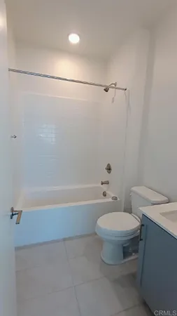 a white toilet sitting next to a bath tub and a shower