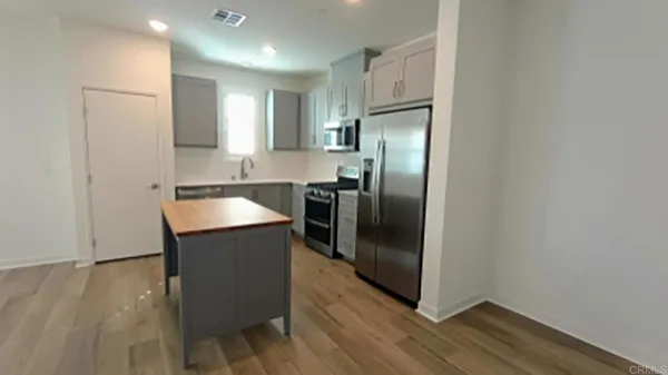 a kitchen with stainless steel appliances granite countertop a refrigerator and a sink