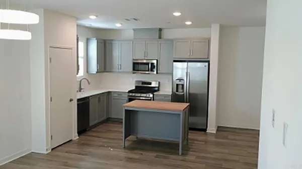 a kitchen with kitchen island stainless steel appliances a sink and refrigerator