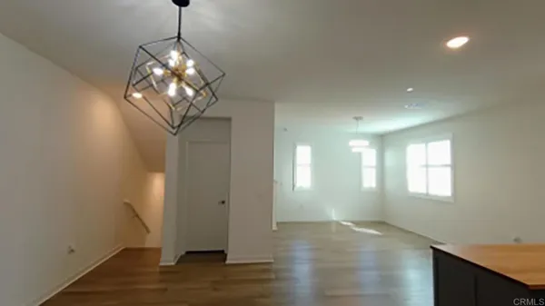 a view of a room with wooden floor and chandelier