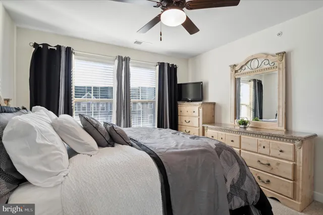 a bedroom with a bed a window and dresser