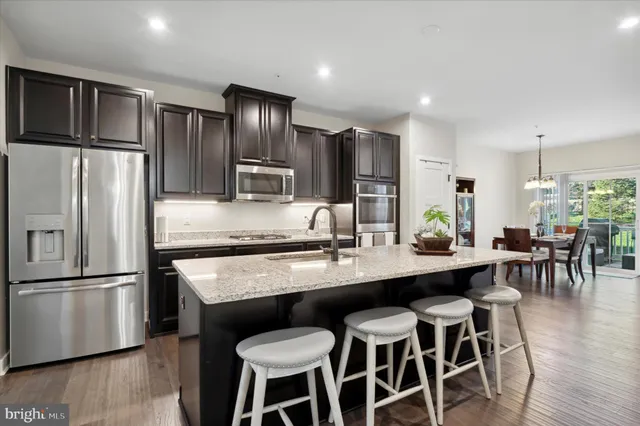 a kitchen with kitchen island white cabinets and stainless steel appliances