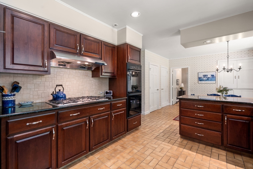 62 Mill Street Sherborn, MA 01770 - Photo 11 of 36 a kitchen with stainless steel appliances granite countertop wooden cabinets and a stove top oven