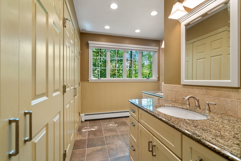 62 Mill Street Sherborn, MA 01770 - Photo 22 of 36 a bathroom with a granite countertop sink a mirror and a shower