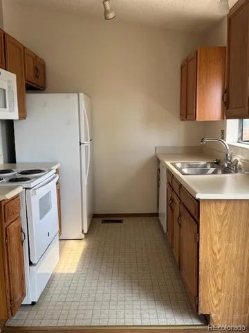 a kitchen with a sink stove and refrigerator