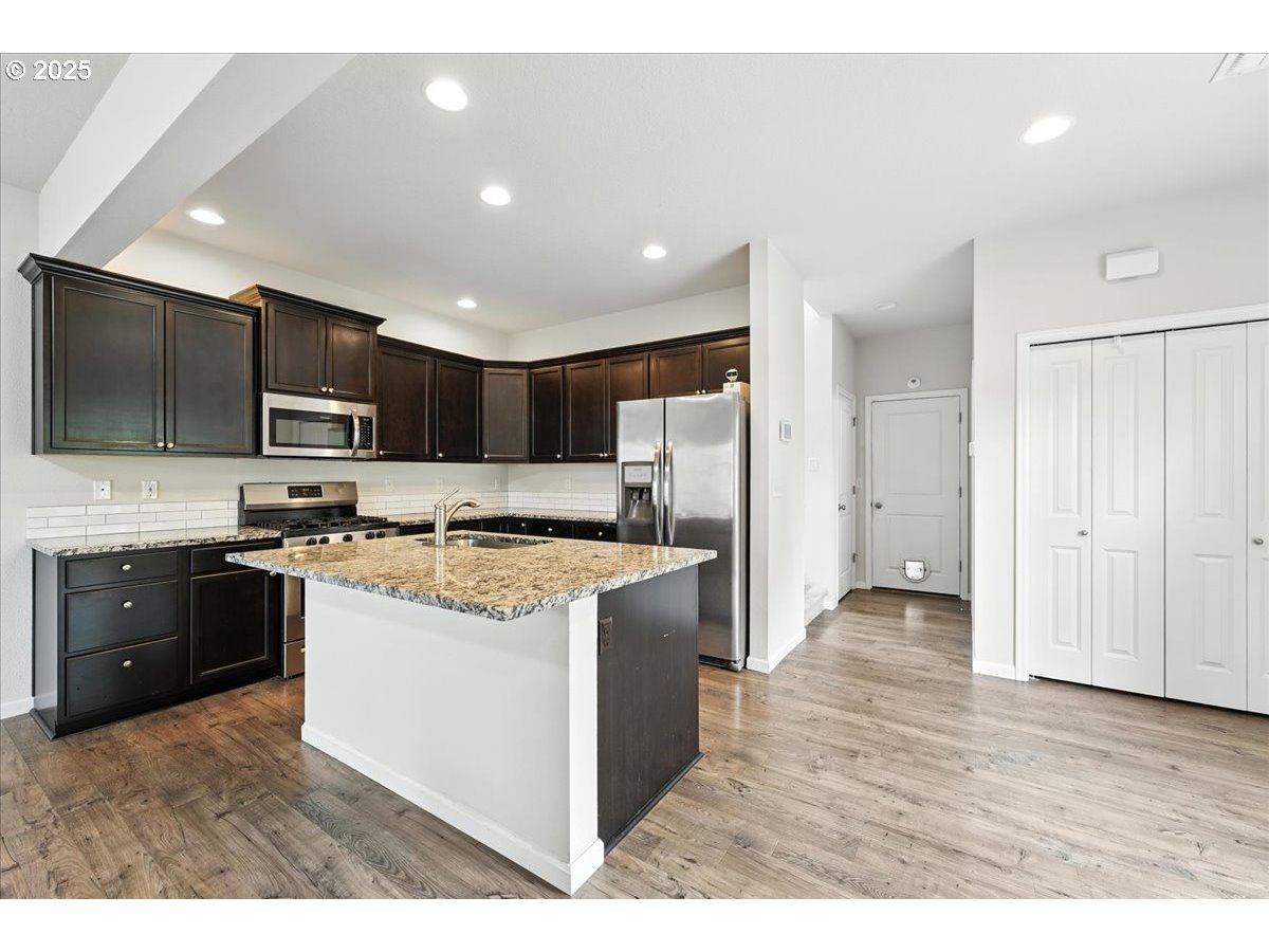 2103 Southeast 18th Alley Gresham, OR 97080 - Photo 6 of 25 a kitchen with stainless steel appliances granite countertop a stove top oven a refrigerator a sink and dishwasher with wooden floor