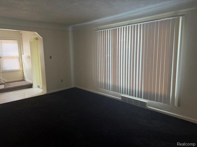 8144 Meyers Road Detroit, MI 48228 - Photo 7 of 19 Bright reception room featuring a large vertical blind-covered window, dark wall-to-wall carpeting, and white baseboards