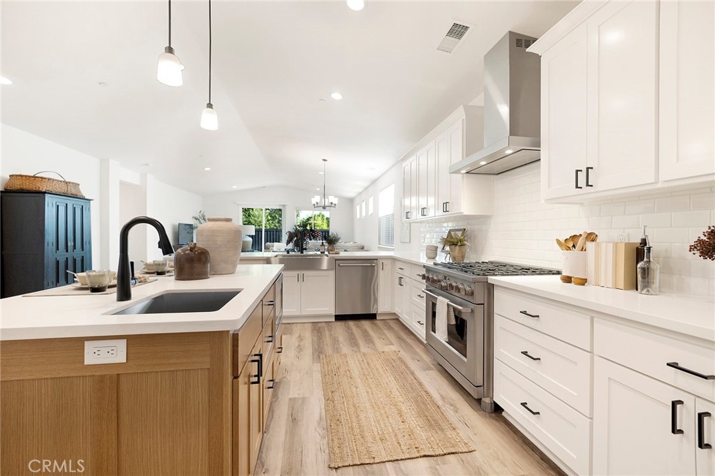 a kitchen with white cabinets appliances and a sink
