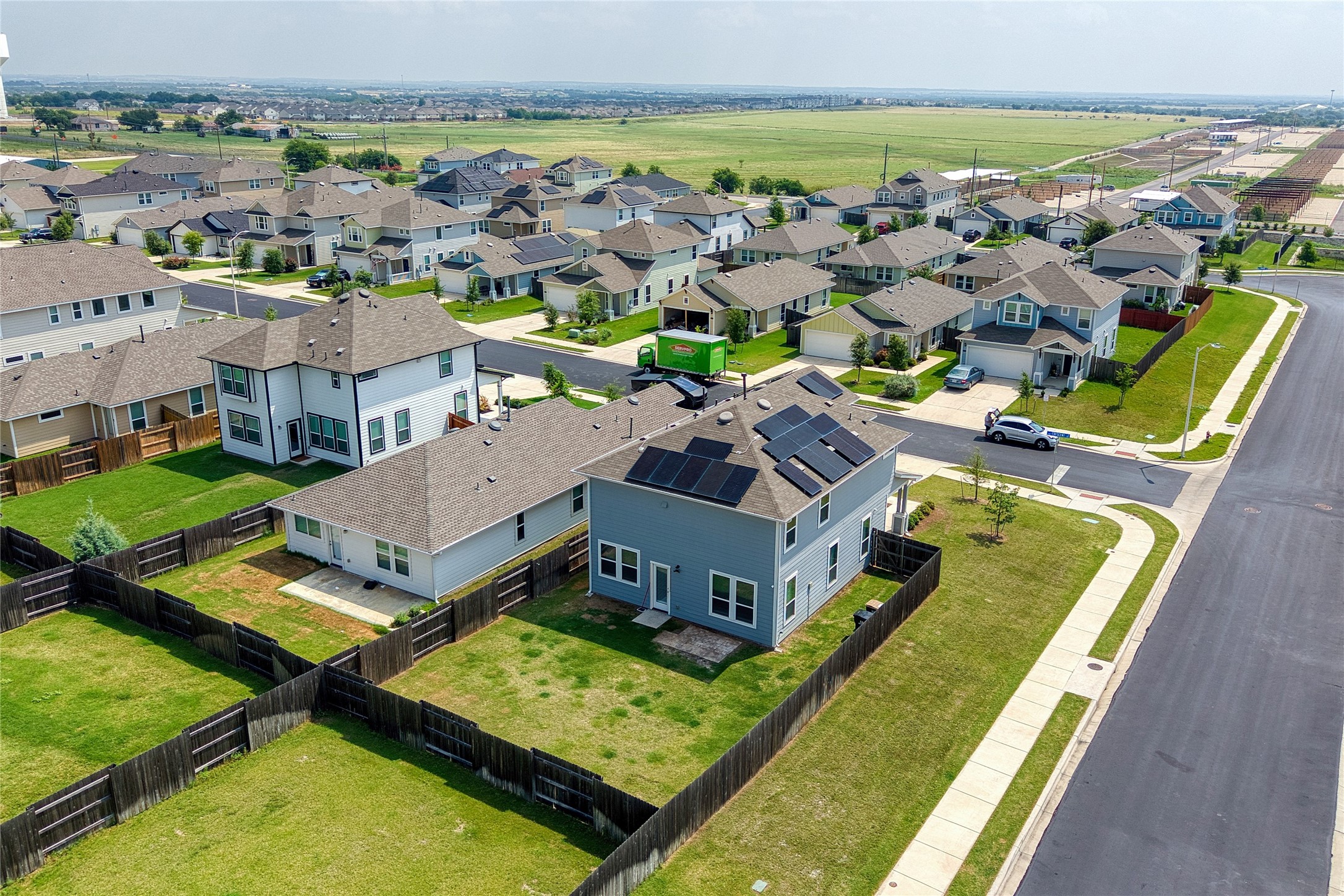 101 Crescent Street Georgetown, TX 78626 - Photo 33 of 39 Aerial view of back of home featuring a neighborhood of modern homes featuring individual solar power systems and ample green space.
