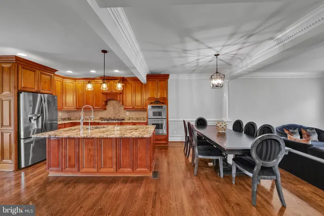 a kitchen with stainless steel appliances granite countertop a sink a stove and a wooden floors