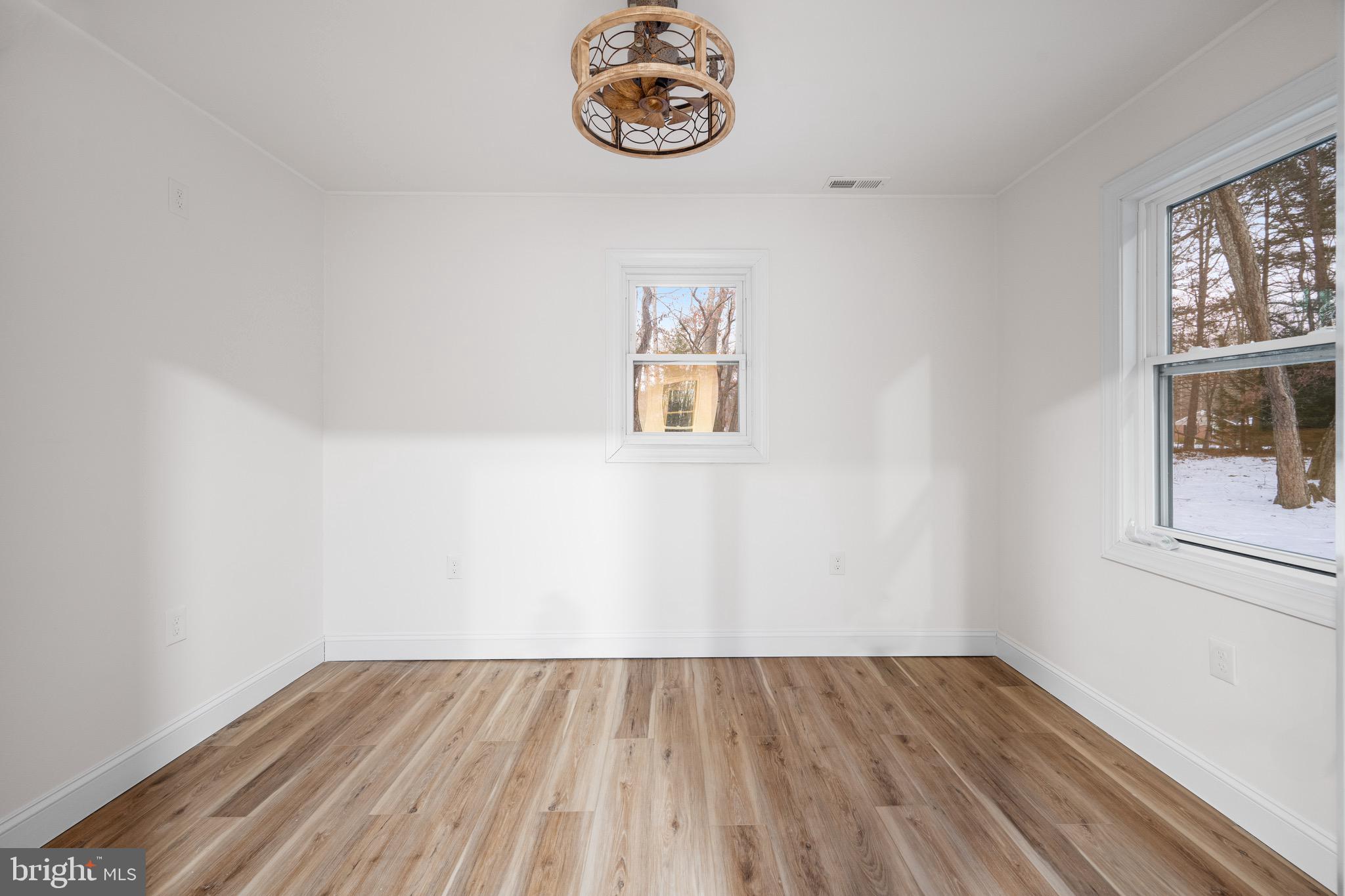 1711 Janvier Road Williamstown, NJ 08094 - Photo 8 of 24 an empty room with wooden floor and windows