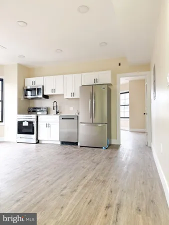 a view of a kitchen with a sink stove cabinets and empty room