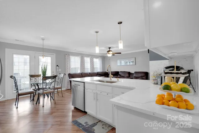 a view of a dining room and livingroom with furniture wooden floor a chandelier