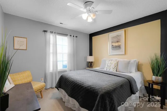 a bedroom with a bed and painting on the wall