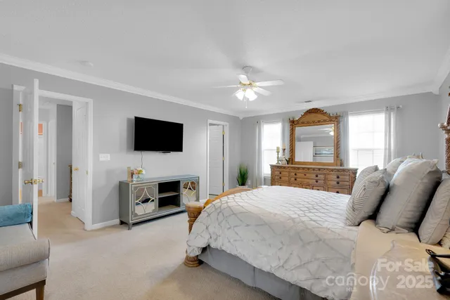 a spacious bedroom with a bed and a flat screen tv