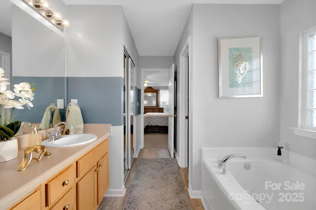 a en suite bathroom with a tub sink and mirror