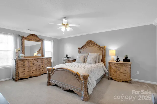 a bedroom with a bed a chandelier and dresser