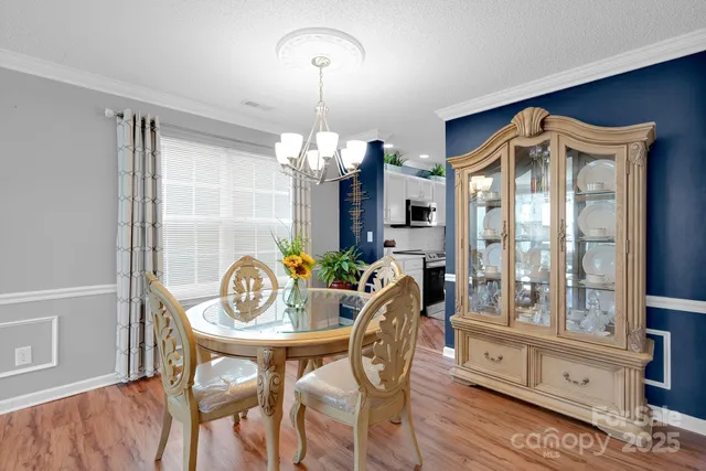 a view of a dining room with furniture a chandelier and wooden floor