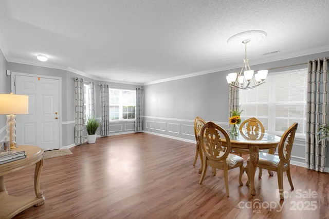a dining room with furniture a chandelier and wooden floor