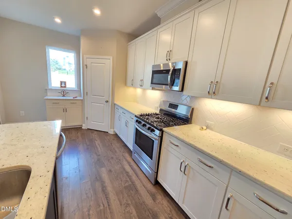 a kitchen with stainless steel appliances granite countertop a sink stove and refrigerator