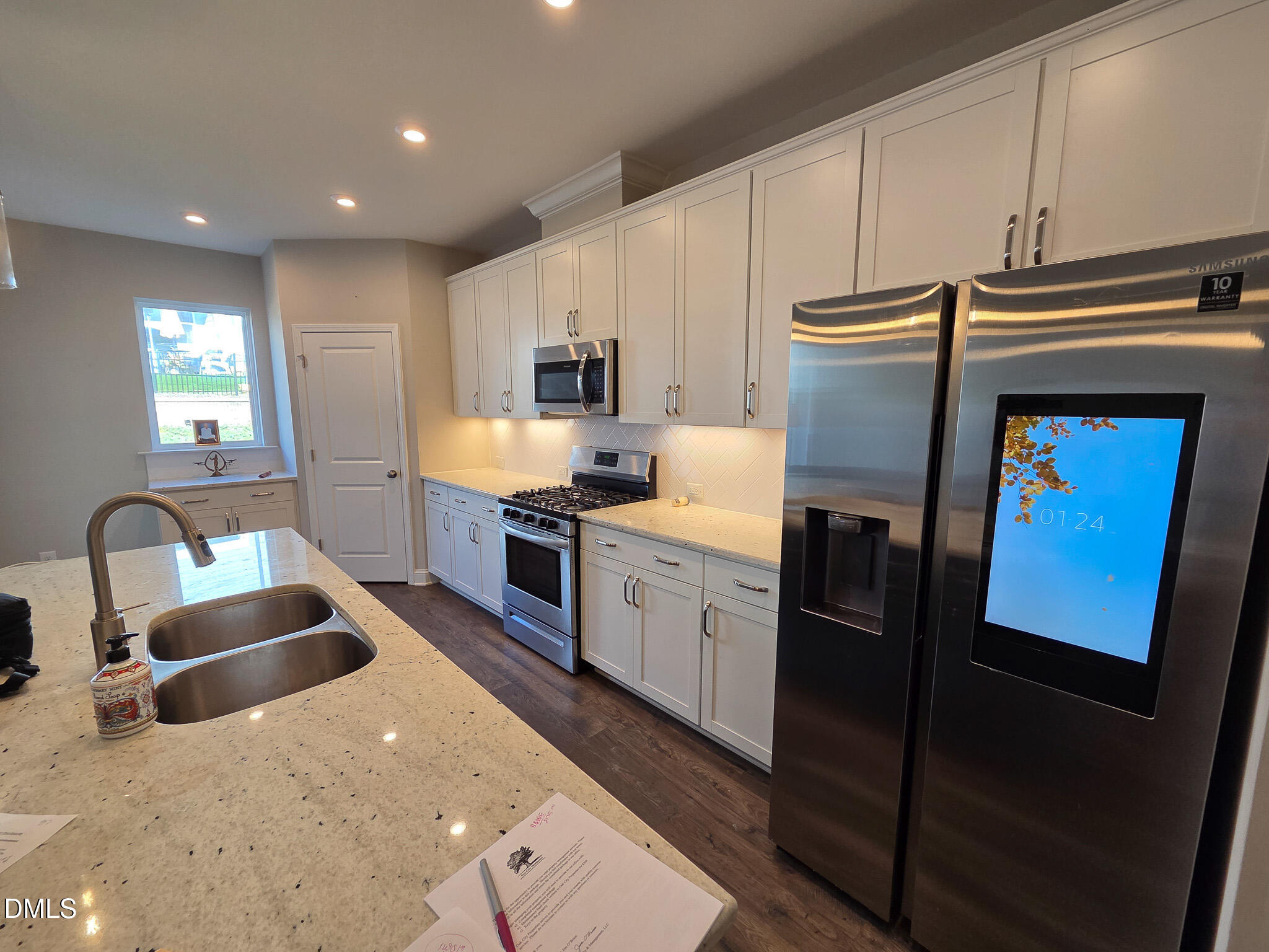 3008 Dunnock Drive Durham, NC 27713 - Photo 15 of 27 a kitchen with granite countertop kitchen island stainless steel appliances a sink a stove a refrigerator a microwave a sink and cabinets